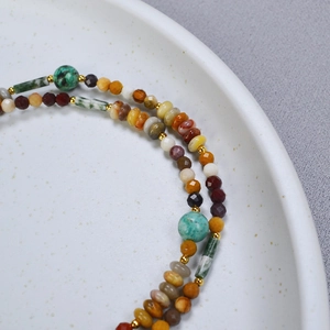 Vue macro d'un collier de perles vintage français avec pierres naturelles et détails dorés