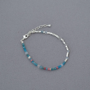 Macro detail of French retro beaded necklace with silver cubes and colorful gemstones