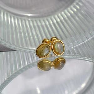 Detail of gold-plated oval stud earrings with iridescent natural labradorite stone