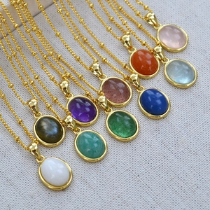 Macro shot of nine oval natural stone necklaces with gold beaded chains in varied colors