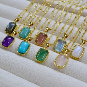 Detailed macro view of colorful rectangular natural stone pendants on gold beaded chains