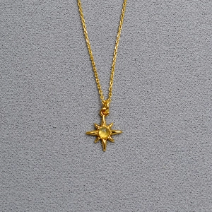 Close-up of gold-plated brass star pendant with labradorite gemstone on a fine chain