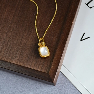 Détail macro d'un collier vintage avec pendentif en cristal rectangulaire et chaîne dorée