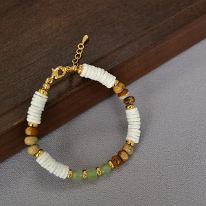Detail of vintage beaded necklace with white shell, brown stone, and green beads