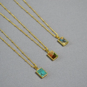 Detailed view of vintage gold chain necklaces with colorful geometric stone pendants