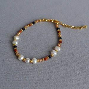 Detailed view of handmade baroque pearl bracelet with gold beads and faceted stone beads