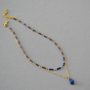 Double-layered beaded necklace with lapis lazuli drop pendant and golden accents