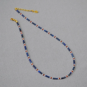 Lapis lazuli beaded necklace with blue cylinders and gold clasp in a layered design
