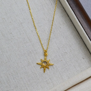 Minimalist gold plated brass octagram star necklace with labradorite stone on jewelry tray