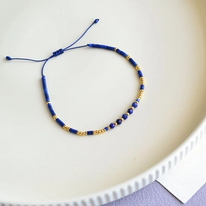 Close-up of Bohemian handmade lapis beaded bracelet with adjustable blue cord