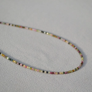 Macro detail of 2mm rainbow tourmaline beaded necklace with polished colorful gemstones