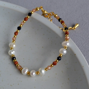 Detail of handmade baroque pearl bracelet with gold beads and sparkling sandstones