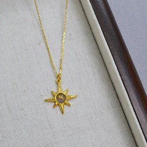 Detail of gold-plated brass necklace featuring labradorite star pendant on jewelry tray