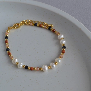 Detail of handmade baroque pearl bracelet with gold beads and blue aventurine stones