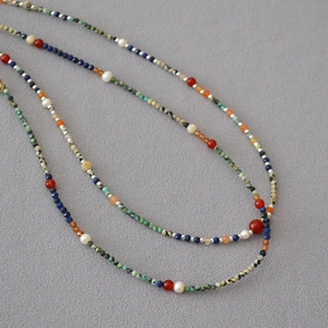 Close-up of lapis lazuli, turquoise, and freshwater pearl beaded necklace details