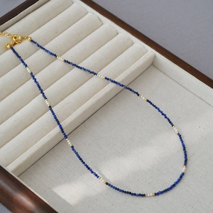 Detail of Lapis Lazuli beads and pearls necklace with golden lobster clasp on velvet tray