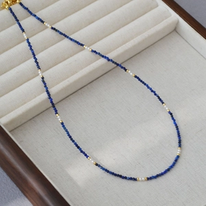 Detailed macro view of retro lapis lazuli and pearl beaded necklace on velvet display