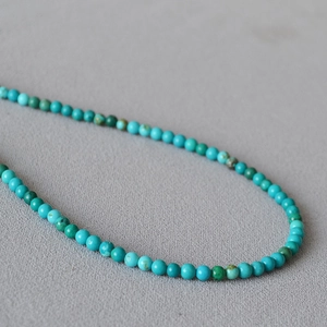 Macro detail of turquoise beaded necklace showing natural stone textures and blue tones