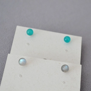Close-up of 925 silver stud earrings with amazonite and labradorite round beads