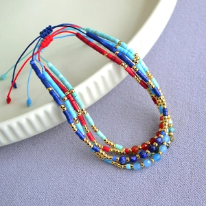Detail of four colorful bohemian beaded bracelets with natural stones and gold spacers