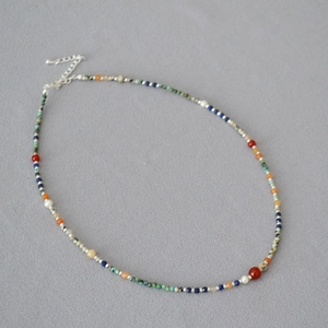 Detail of a handmade colorful gemstone beaded necklace with silver lobster clasp and chain