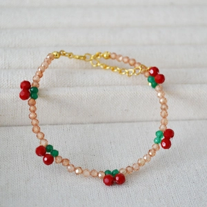 Close-up of handmade cherry beaded bracelet with champagne zircon crystals and gold clasp