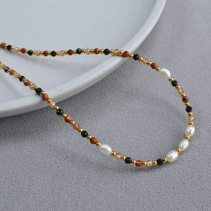 Detailed macro of Baroque pearl necklace with gold-sand and blue-sand faceted beads