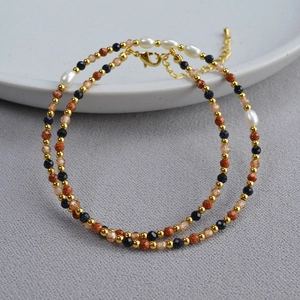 Detail of baroque pearl necklace with blue sand stones and golden lobster clasp