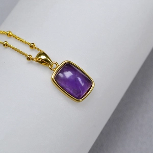 French vintage brass necklace featuring a rectangular purple gemstone with a gold chain