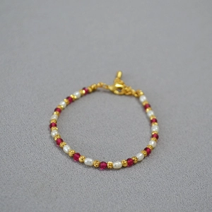 Macro detail of French style beaded necklace with tiny pearls and red corundum beads
