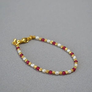 Close-up of elegant beaded necklace with red corundum and rice-shaped pearls