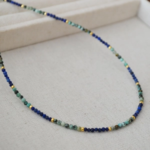 Detailed macro of handmade lapis lazuli and turquoise beaded necklace with gold spacers