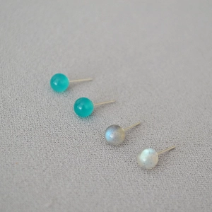 Close-up of minimalist 925 silver stud earrings with moonstone and amazonite stones