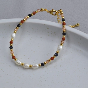 Detail view of baroque pearls with blue goldstone beads on a golden chain bracelet