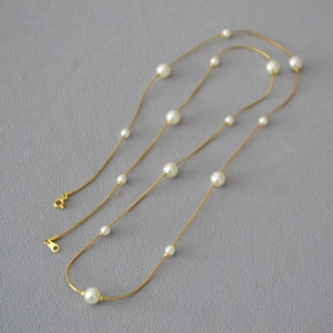Elegant gold-plated snake chain necklace with spaced white pearls for a minimalist look