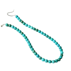 Minimalist turquoise beaded necklace with silver lobster clasp on a clean white background