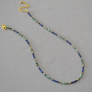 Detail of beaded necklace with lapis lazuli, turquoise, and gold metal accents