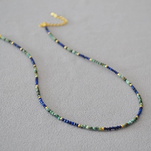 Detail of beaded necklace with turquoise and lapis lazuli stones and golden clasp