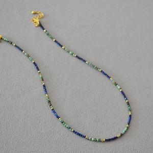 Detailed macro view of handmade turquoise and lapis lazuli beaded necklace with gold spacers