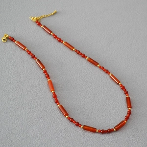 Macro detail of red carnelian beads and gold spacer disks on this vintage style necklace
