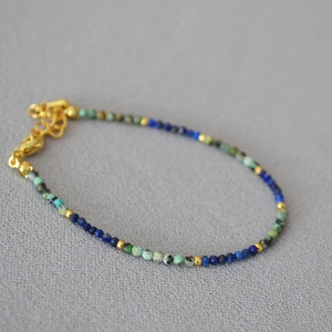 Detailed shot of handmade turquoise and lapis lazuli beaded necklace with gold lobster clasp