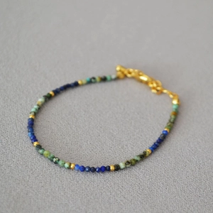 Detail of handmade beaded necklace with turquoise lapis lazuli and gold metal spacers