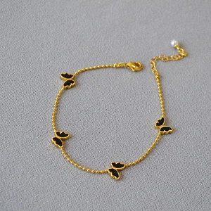 Bracelet papillon élégant plaqué or avec émail noir et pendentif en perle blanche