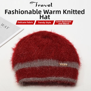 Détail du bonnet en maille peluche rouge avec bord gris et broche ondulée dorée