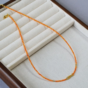 Collier de perles orange avec pendentif carpe koi dorée dans son écrin à bijoux