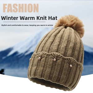Detail of coffee brown knit hat featuring wavy weave texture, pearls and faux fur pompom