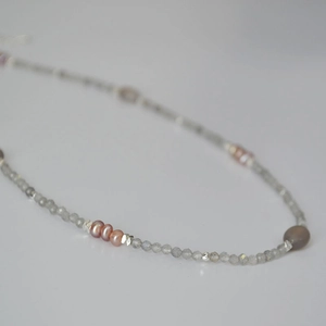 Detailed macro view of minimalist labradorite beads and pink freshwater pearl necklace