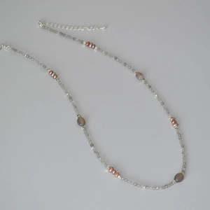 Detail of beaded necklace with grey labradorite stones and pink freshwater pearls