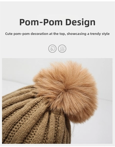 Detail of fluffy brown faux fur pom-pom on the top of a cable knit beanie for winter
