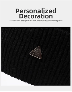 Detail of black ribbed knit beanie featuring a classic inverted triangular metal logo plaque